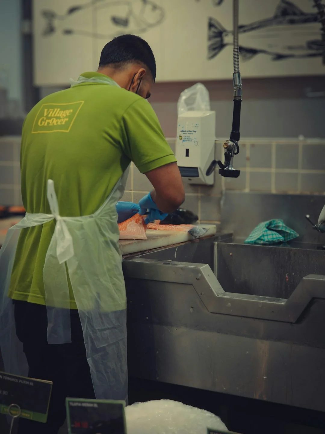 Anonymous person in yellow rubber gloves using simple sponge for cleaning mirror in bathroom