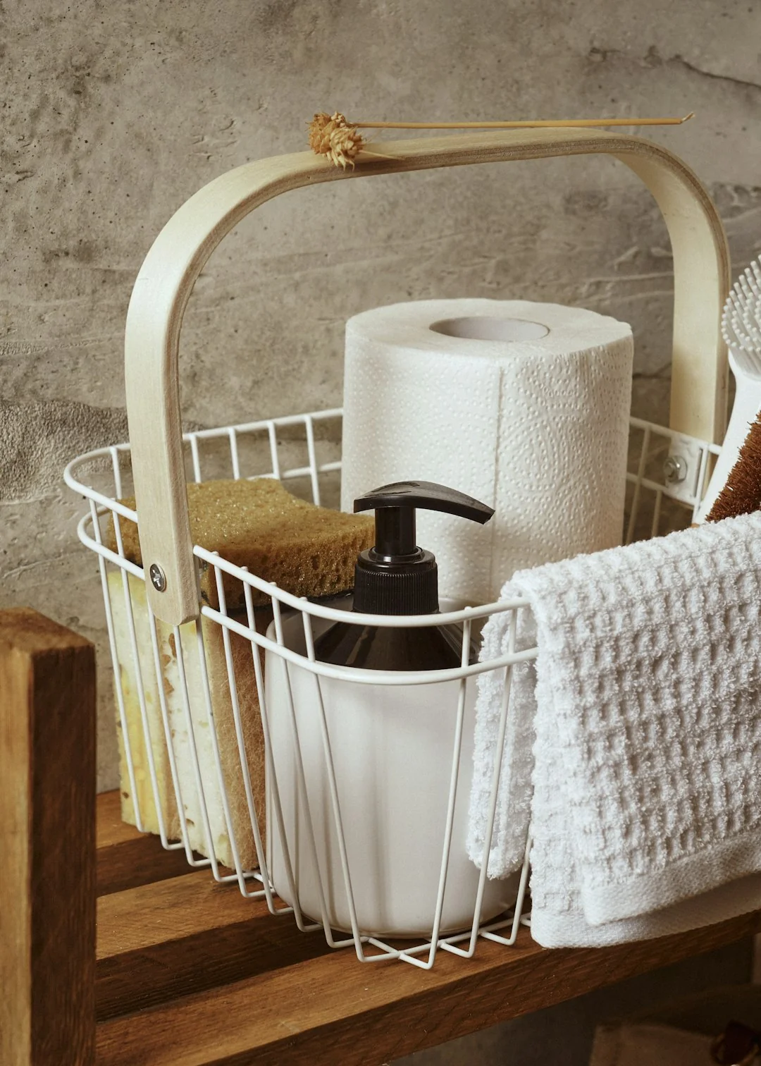 Person using spray bottle and cloth for cleaning a kitchen shelf, ensuring hygiene and cleanliness.